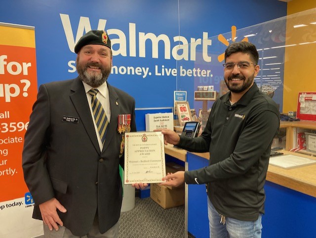 Comrade Rob Pitcher presents a Certificate of Appreciation to Parshant Gautam from the Bedford Walmart for their support during the 2022 Poppy Campaign